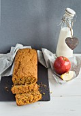 Carrot cake, a fresh apple and a bottle of milk