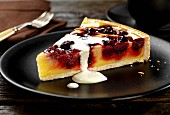 A slice of cherry and vanilla pudding tart with cream