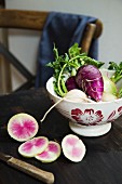 Various turnips in a ceramic bowl on a wooden table