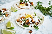 Tacos with sweet potatoes, fried egg, cheese and coriander
