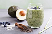 Green avocado and spinach smoothie with blueberries and chia seeds