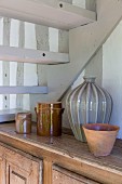 Stoneware pots on top of cabinet below staircase