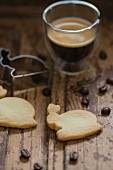 A glass of espresso with biscuit cutters and rabbit shaped biscuits