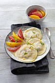 Ravioli filled with grapes served with citrus fruits
