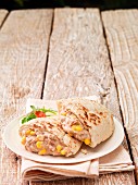 Pita bread filled with tuna and sweetcorn salad on a plate