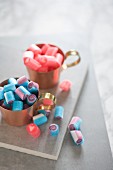 Blaue & rosafarbene Bonbons in Kupfertassen