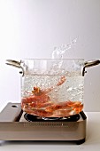Shrimps being boiled in a glass pot