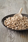 Chickpeas in a bowl with a wooden scoop