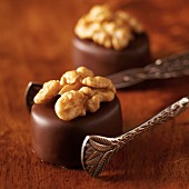 A walnut and marzipan praline with silver tongs
