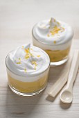 Two glasses of lemon curd with cream and lemon zest