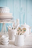 White crockery and cutlery against a light blue wooden wall