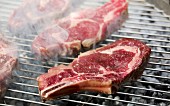 Raw beef chops on a barbecue