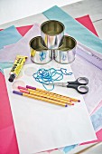 Craft supplies for making Advent calendar from tin can, stickers, rubber bands and tissue paper