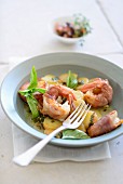 Prawns wrapped in bacon with potatoes and basil
