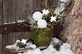 Planter wrapped in moss and decorated with baubles and stars