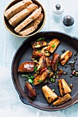 Fried aubergines with chillis in the pan