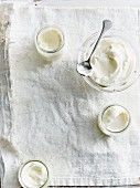Yoghurt in glasses and a glass bowl seen from above