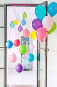 Colourful balloons tied to door frame and door
