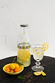 Zitronenlimonade in dekorierter Flasche und Glas