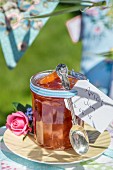 Homemade apricot jam in a jar on a table outside