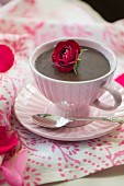 Chocolate pudding in a cup garnished with a rose
