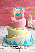 A slanted topsy-turvy cake decorated with pastel-coloured fondant icing