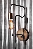 Retro industrial-style sconce lamp on corrugated metal wall