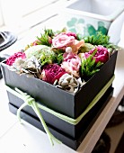 Schwarze Geschenkbox mit Büten dekorativ ausgestaltet