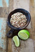 Coloured quinoa in a wooden bowl with a lime next to it