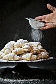 Rugelach or Rogaliki (Russian jam pastries) being dusted with icing sugar