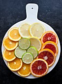 Lemon, lime, orange, and blood orange slices on a white tray (seen from above)