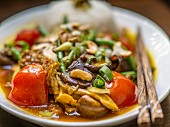 Hähnchen in Sauce mit Pilzen, Cashews, Tomaten, Bohnen und Reisbeilage (Asien)