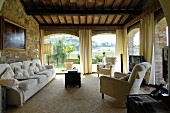 Mediterranes Wohnzimmer mit Steinwand und Panoramafenstern