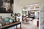 View past collection of globes into open-plan kitchen with dining area