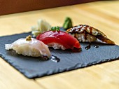 Drei verschiedene Sushi auf Schieferplatte