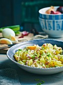 Potato salad with diced bacon and three types of onions