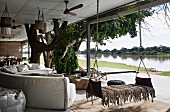 Sofa landscape and hanging lounger on covered terrace, river view