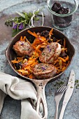 Fried pork medallions on a dried plum and carrot medley