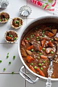 Hearty beef stew in a pot and in pastry cases
