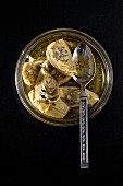 Marinated artichokes in a jar with a spoon