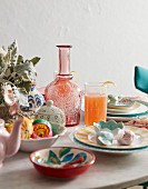 Place settings with painted plates and Christmas decorations in bowl on table