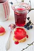 Sloe jelly in a glass and on a piece of bread