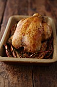 A whole roast chicken in a roasting tin