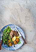 Lamb chops on potatoes, asparagus and peas