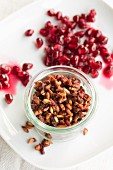 Organic pomegranate seeds, fresh and dried, in a jar for muesli