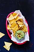 An avocado dip with chilli and tortilla chips