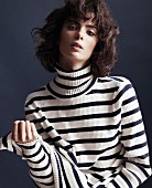 A young woman wearing a blue-and-white striped roll-neck jumper