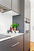 View of the anthracite-colored kitchenette with marble kitchen worktop and splash guard