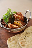 Boiled eggs with red masala and naan bread (India)