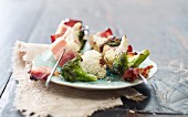 Grilled cauliflower and broccoli skewers with bacon on a plate